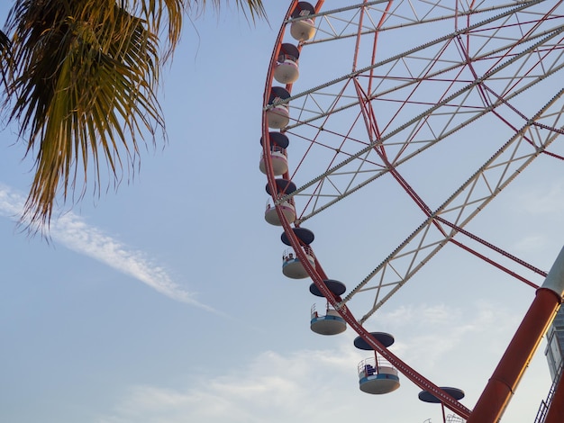 Roda-gigante contra o céu Parque de diversões à beira-mar Zona de descanso Mecanismo redondo Amantes de altura