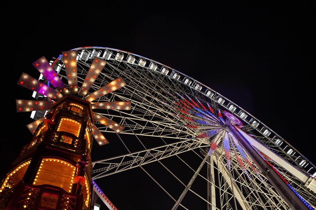 Roda gigante e carrossel iluminado à noite