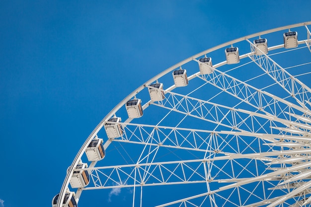 Roda-gigante grande branca com fundo de nuvens nítidas de céu azul