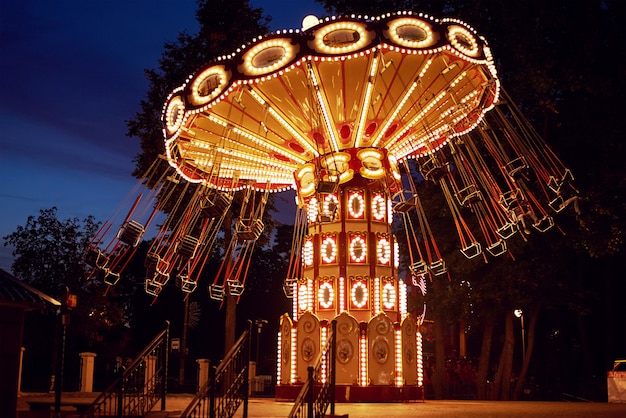 Foto roda gigante iluminada no parque de diversões na cidade à noite