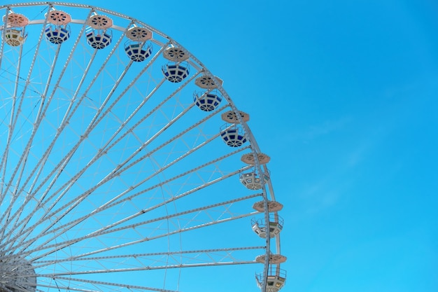 Roda-gigante no fundo do céu azul. no parque de diversões. o fim de semana