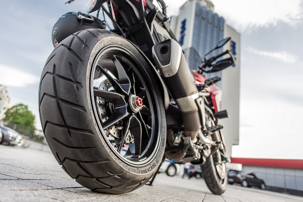 Roda traseira da motocicleta vermelha na rua da cidade