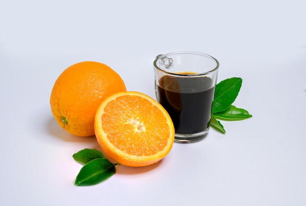 Rodaja de naranja con naranja fresca y café caliente y hojas verdes aisladas sobre fondo blanco.