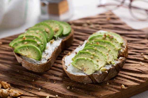 rodajas de aguacate sobre pan tostado con nueces