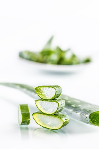 Rodajas de aloe vera con gel sobre fondo blanco.