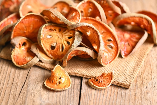 Rodajas de bael secas sobre fondo de madera Bael para jugo de bael Té de frutas de bael seco para la salud Aegle marmelos