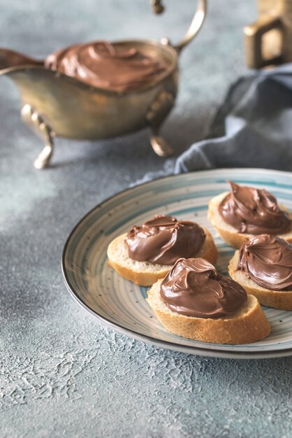 Rodajas de baguette con crema de chocolate en el plato