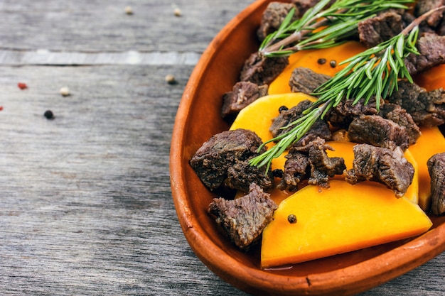 Rodajas de calabaza al horno con carne en una olla de barro