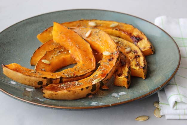 Rodajas de calabaza al horno, espolvoreadas con hierbas secas, rociadas con aceite de oliva.