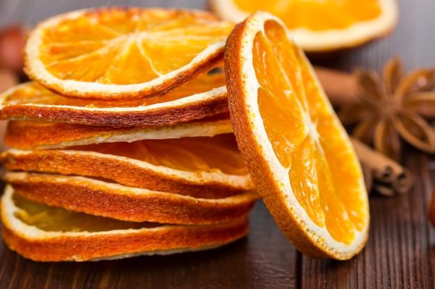 Rodajas de canela naranja seca y anís estrellado sobre un fondo de madera