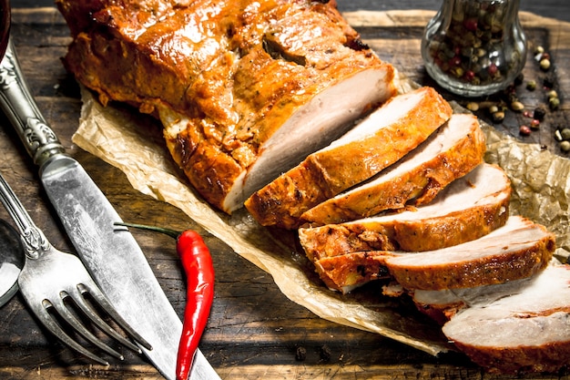 Rodajas de carne a la brasa en una tabla con especias. En la pizarra negra.