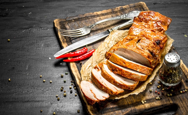 Rodajas de carne a la brasa en una tabla con especias.