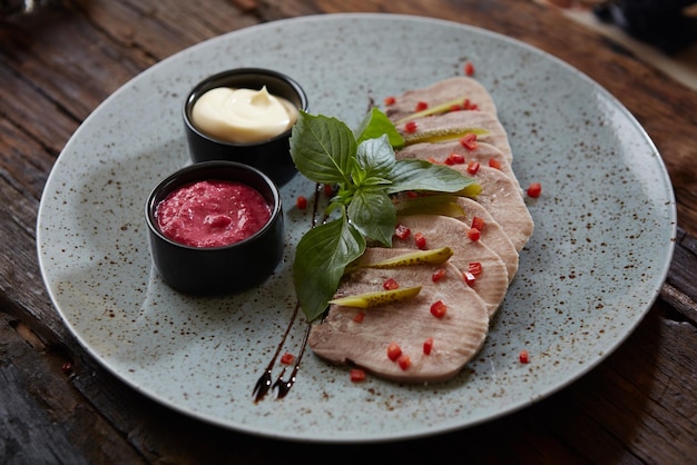 Rodajas de cerdo al horno frío con hierbas en plato azul