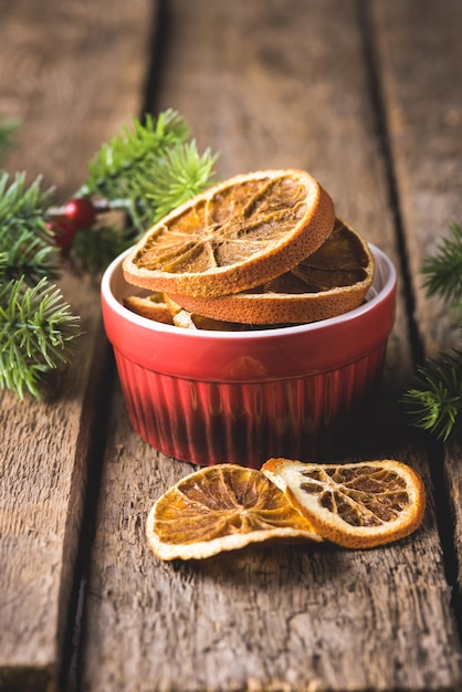 Rodajas de chips de naranja en el fondo de madera Red Bowl