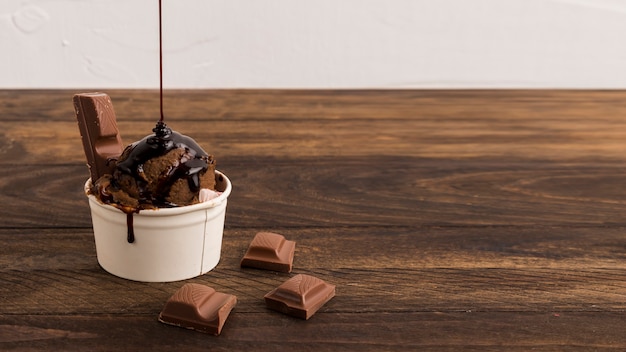 Foto rodajas de chocolate y helado con almíbar en un tazón blanco