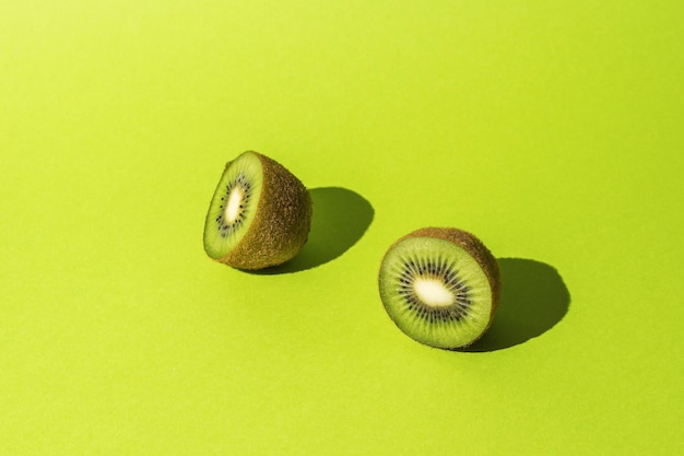 Rodajas de fruta de kiwi fresco sobre un fondo verde brillante. Frutas tropicales.