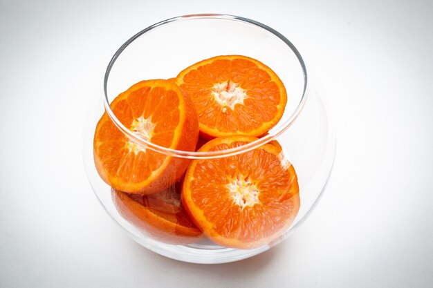 Las rodajas de fruta naranja en florero de vidrio