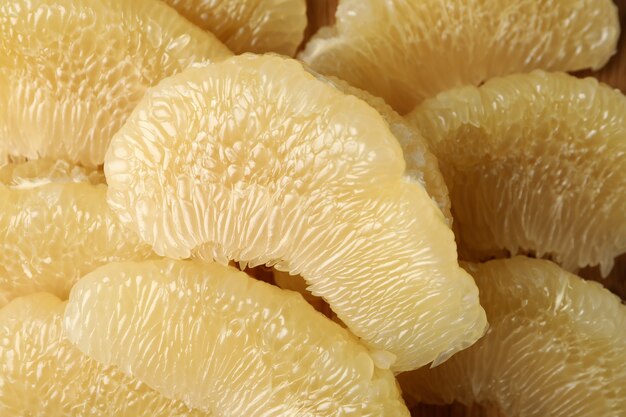 Rodajas de fruta de pomelo madura sobre todo el fondo, cerrar