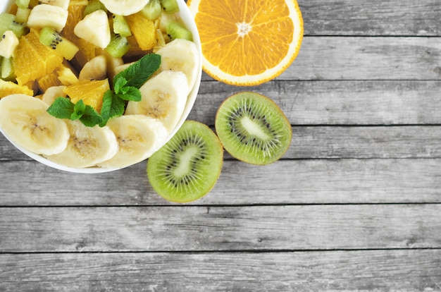 Foto rodajas de frutas en un recipiente sobre un fondo de madera