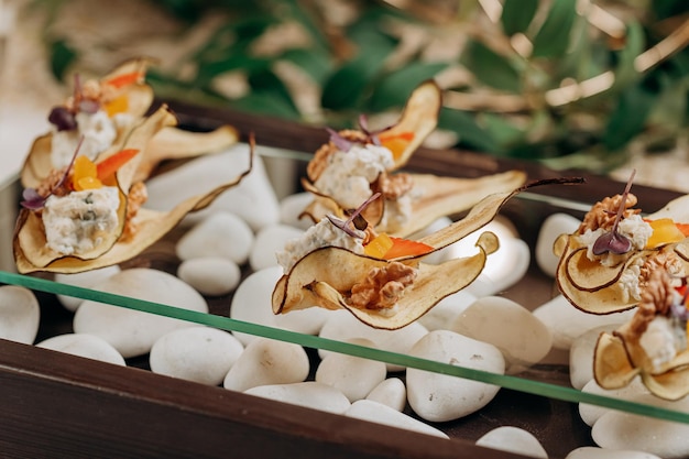 Rodajas de frutos secos chips de pera con requesón y nueces saludable postre vegano sin azúcar servido para furshet en restaurante