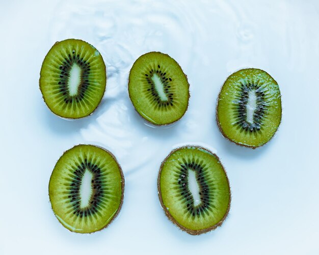 Rodajas de kiwi en rodajas en agua con gotas