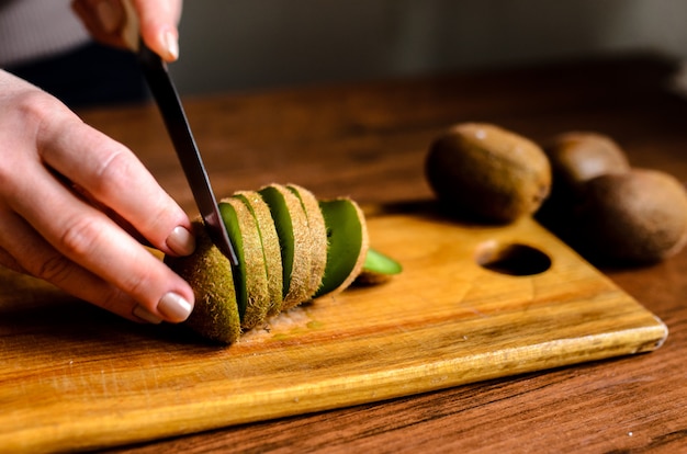 Rodajas de kiwi sobre una plancha de madera.