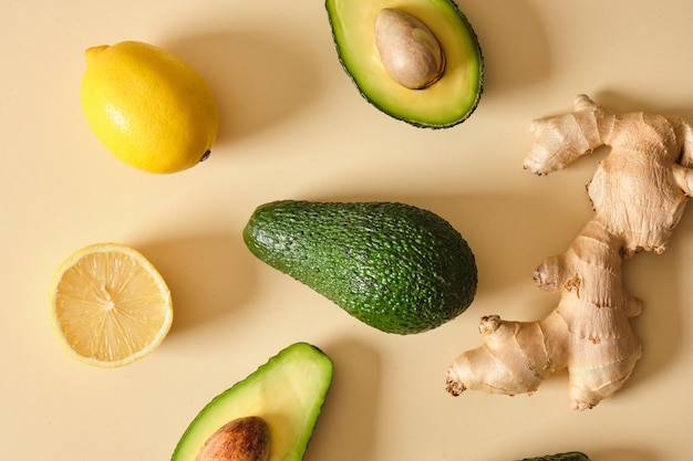 Rodajas de limón aguacate y jengibre sobre fondo beige