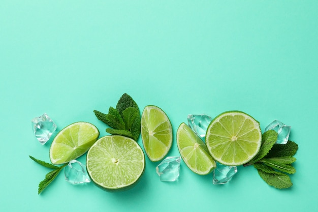 Foto rodajas de limón, cubitos de hielo y hojas de menta sobre fondo de menta