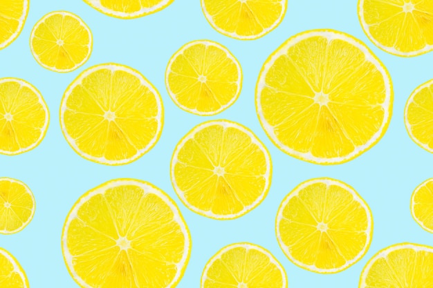 Rodajas de limón de patrones sin fisuras de verano sobre un fondo azul claro