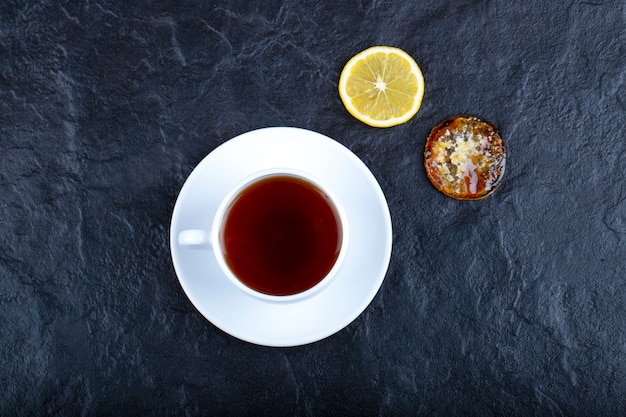 Rodajas de limón a la plancha y una taza de té caliente en el cuadro negro