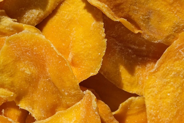 Rodajas de mango seco primer plano sobre un fondo blanco Vista superior Primer plano Fondo de chips de mango Trozos de rodajas de fruta crujientes deshidratadas Montón de fruta amarilla seca al sol Comida saludable Vista superior endecha plana