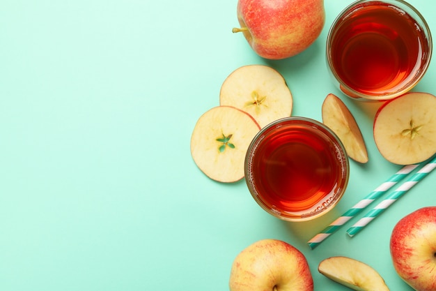 Rodajas de manzana, pajitas y vasos de jugo de manzana con menta