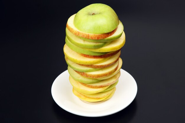 Rodajas de manzana en rodajas sobre una placa blanca.