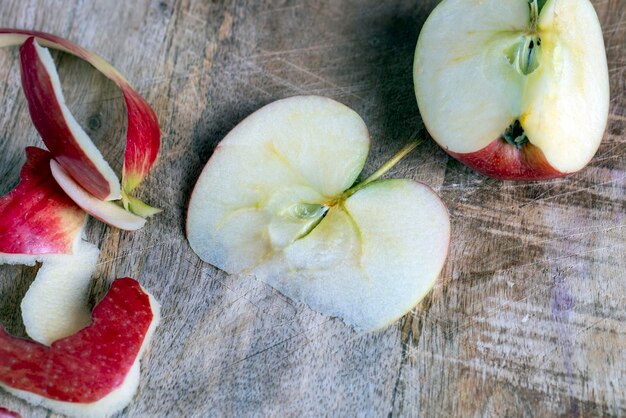 Rodajas de manzana roja madura y jugosa cortando una tabla vieja con trozos de manzana roja madura