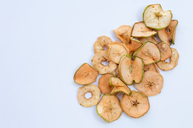 Rodajas de manzana seca sobre fondo blanco.