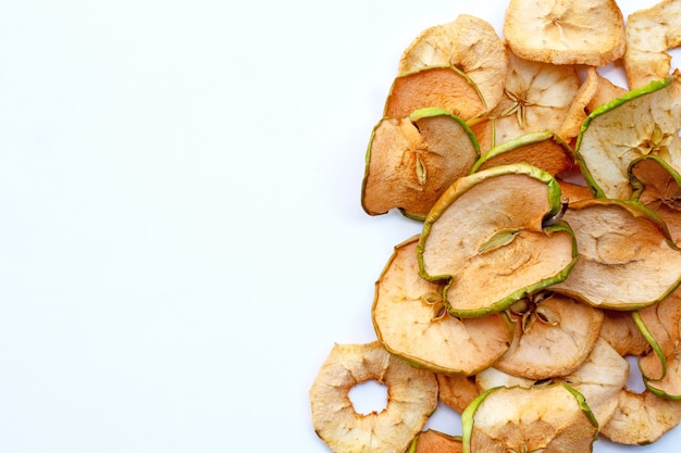 Rodajas de manzana seca sobre fondo blanco.