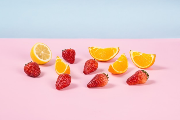 Foto rodajas de naranja y fresas en la mesa