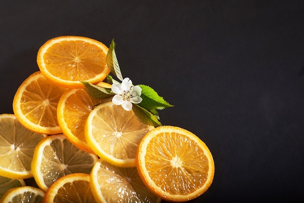 Rodajas de naranja y limón, aisladas en negro.