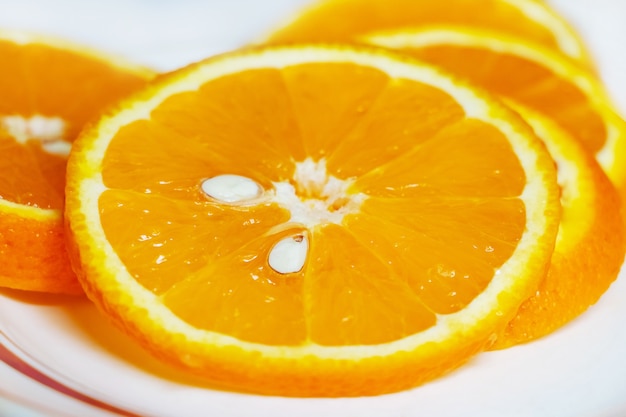 Rodajas de naranja en rodajas en un plato, frutas cítricas