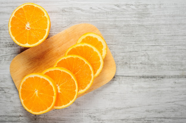 Rodajas de naranjas frescas sobre fondo de madera blanca