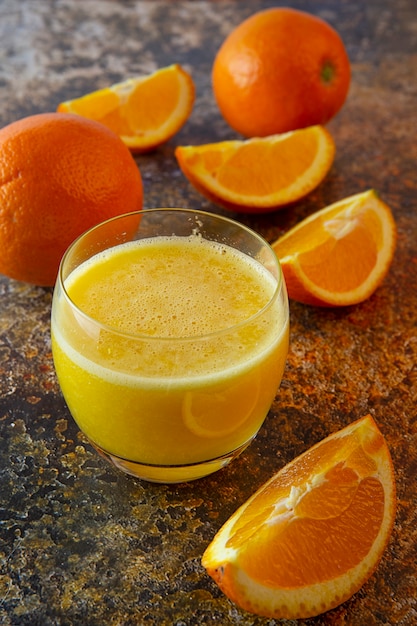 Rodajas de naranjas y jugo de naranja sobre la mesa.