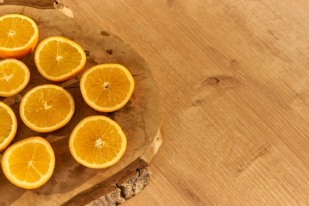 Rodajas de naranjas orgánicas frescas sobre una mesa de cocina de madera.