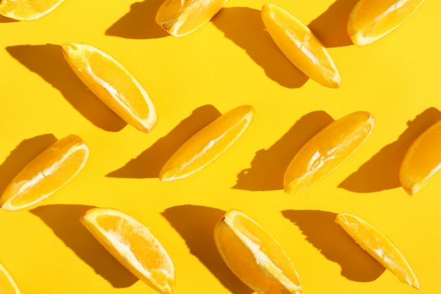 Foto rodajas de naranjas sobre un fondo amarillo, papel tapiz de patrón brillante.