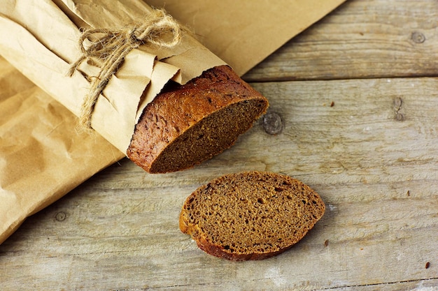 Rodajas de pan empacado en papel sobre mesa de madera