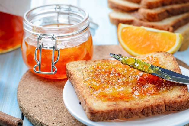 Rodajas de pan tostado con mermelada de naranja para el desayuno.