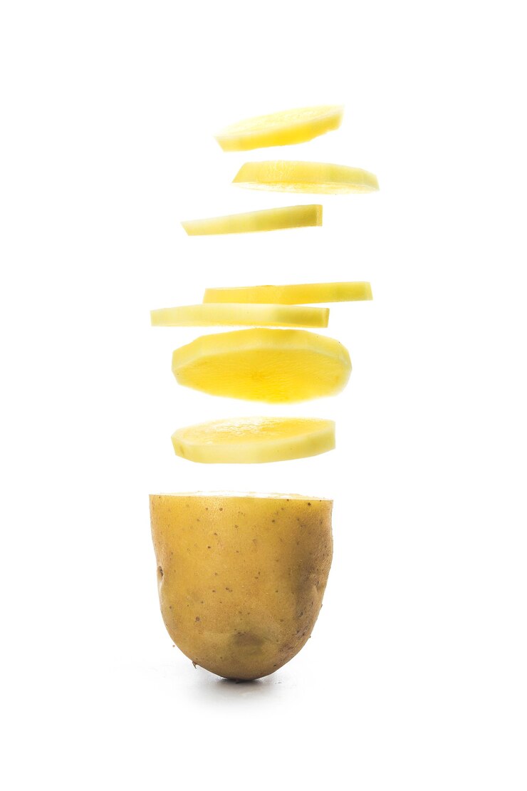 Rodajas de patata convirtiéndose en chips aislado sobre fondo blanco.