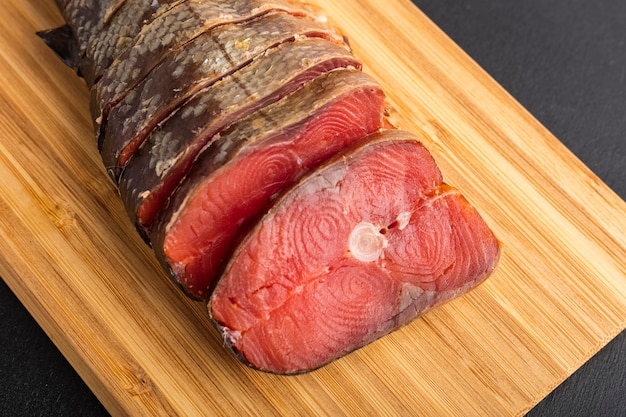 Rodajas de pescado ahumado Salmón rosado sobre una tabla de cortar closeup