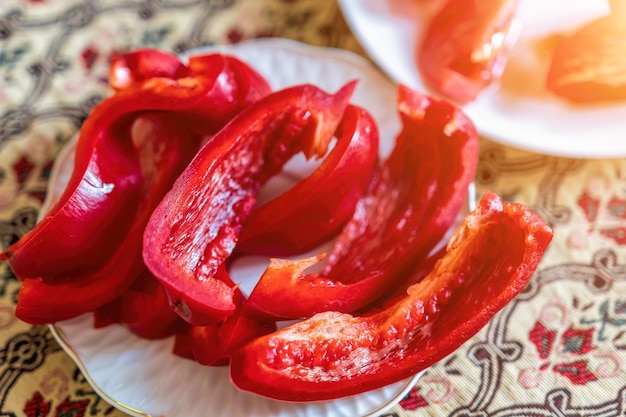 Rodajas de pimientos rojos en un plato blanco sobre una mesa comida saludable en casa