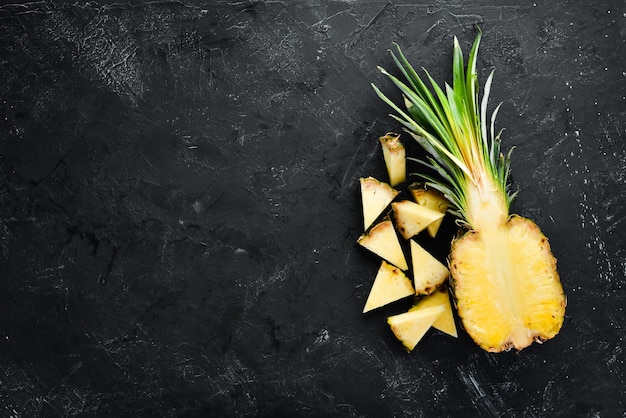 Rodajas de piña sobre un fondo negro Frutas tropicales Vista superior Espacio de copia libre