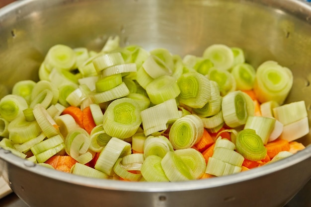 Rodajas de puerros y zanahorias en un recipiente para cocinar
